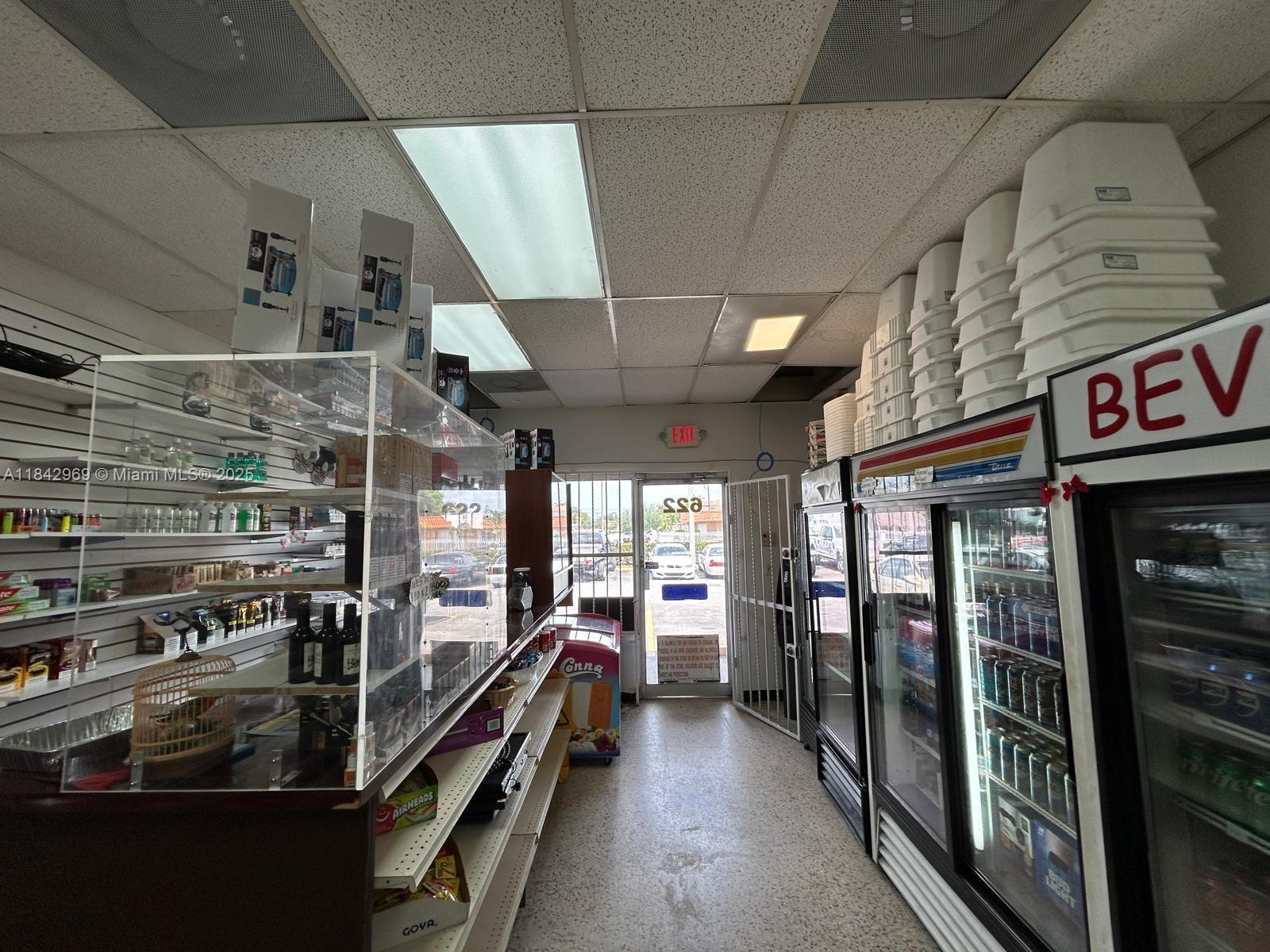 A small convenience store interior features a glass display counter, shelving, and beverage refrigerators — 622 E 9th Street, Hialeah FL 33010, HIALEAH, FL