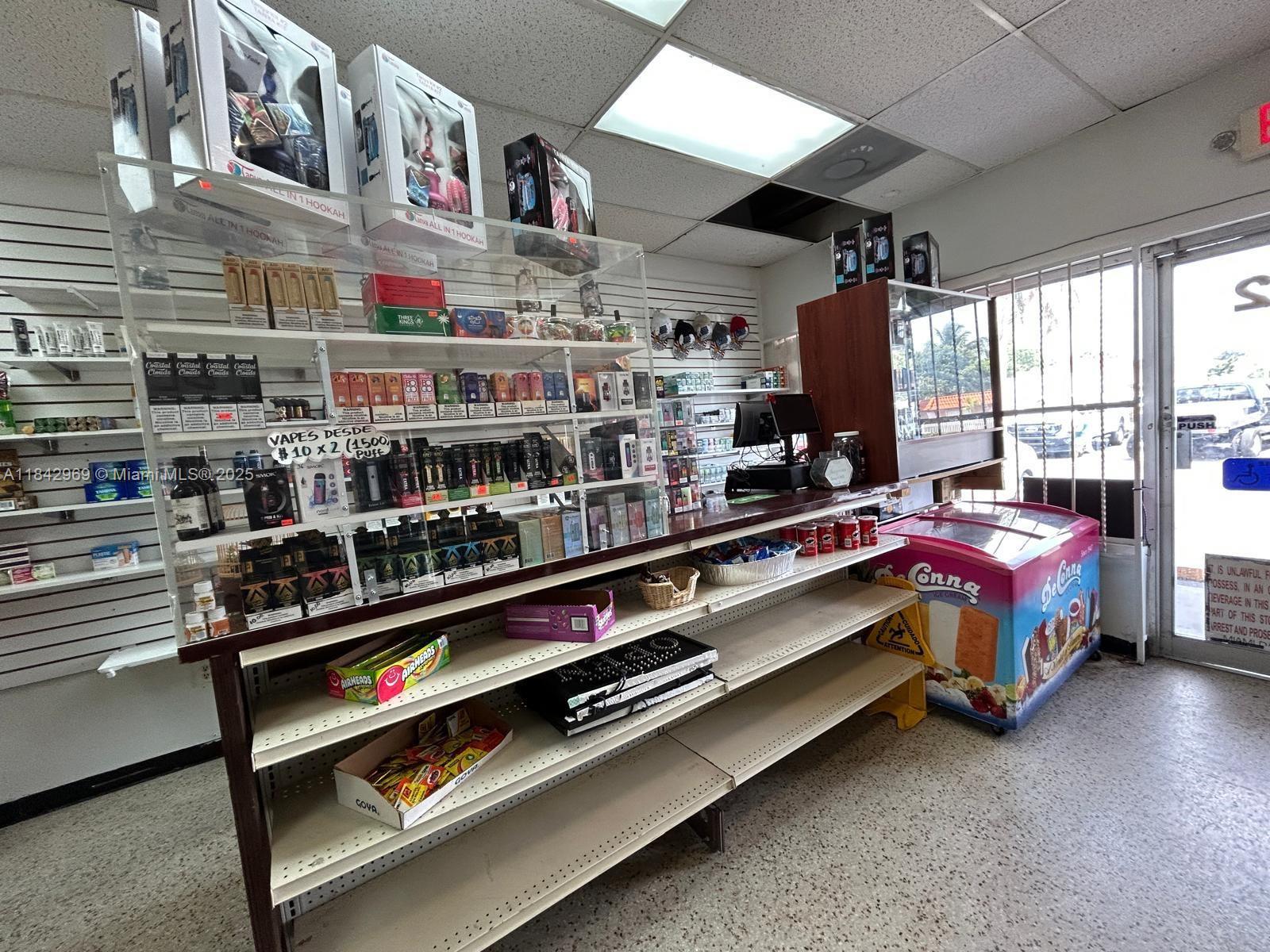 A retail store interior features shelves stocked with vaping products, snacks, and an ice cream freezer — 622 E 9th Street, Hialeah FL 33010, HIALEAH, FL