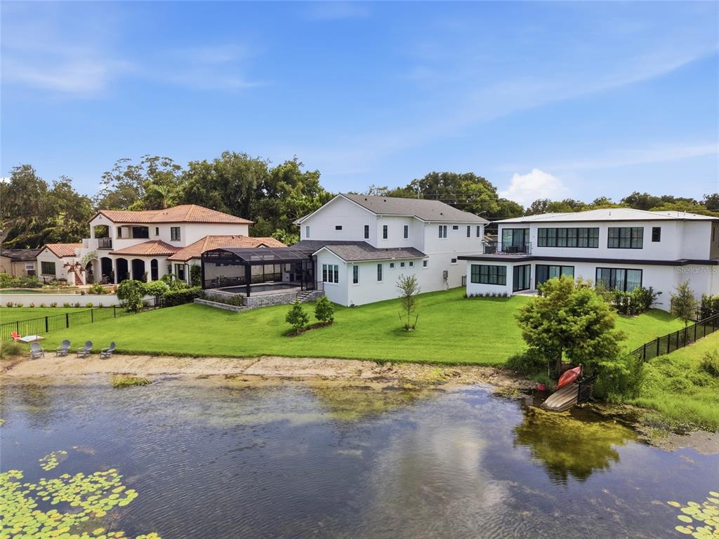 An aerial view shows three large houses with backyards bordering a lake — 3001 S OSCEOLA AVENUE, ORLANDO, FL