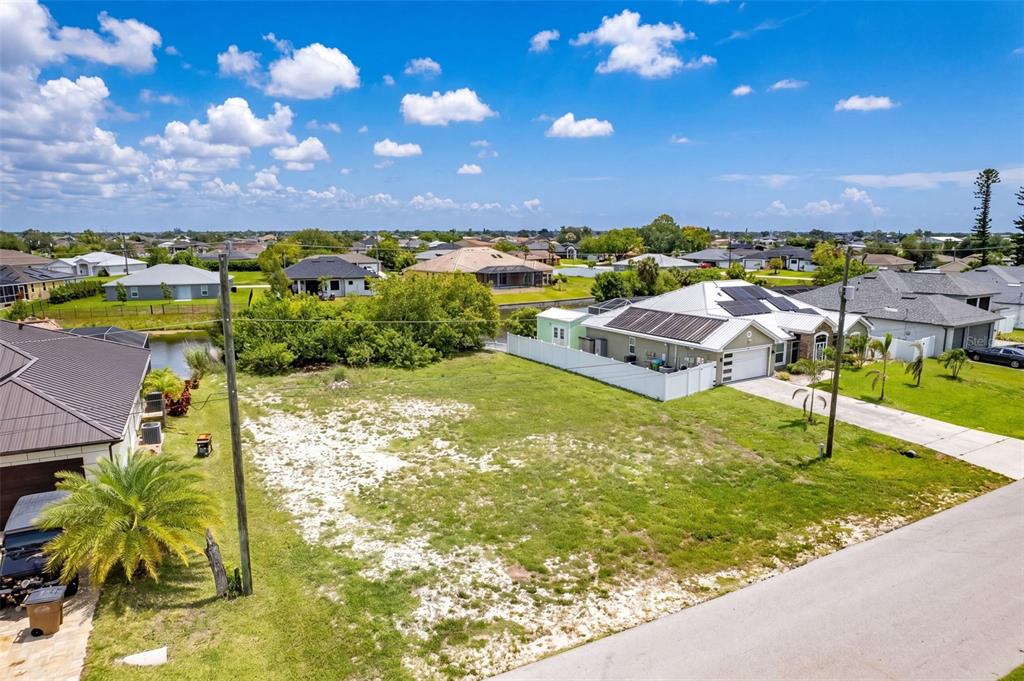 An elevated view of a vacant residential lot situated between two houses — 623 NE 7TH TERRACE, CAPE CORAL, FL