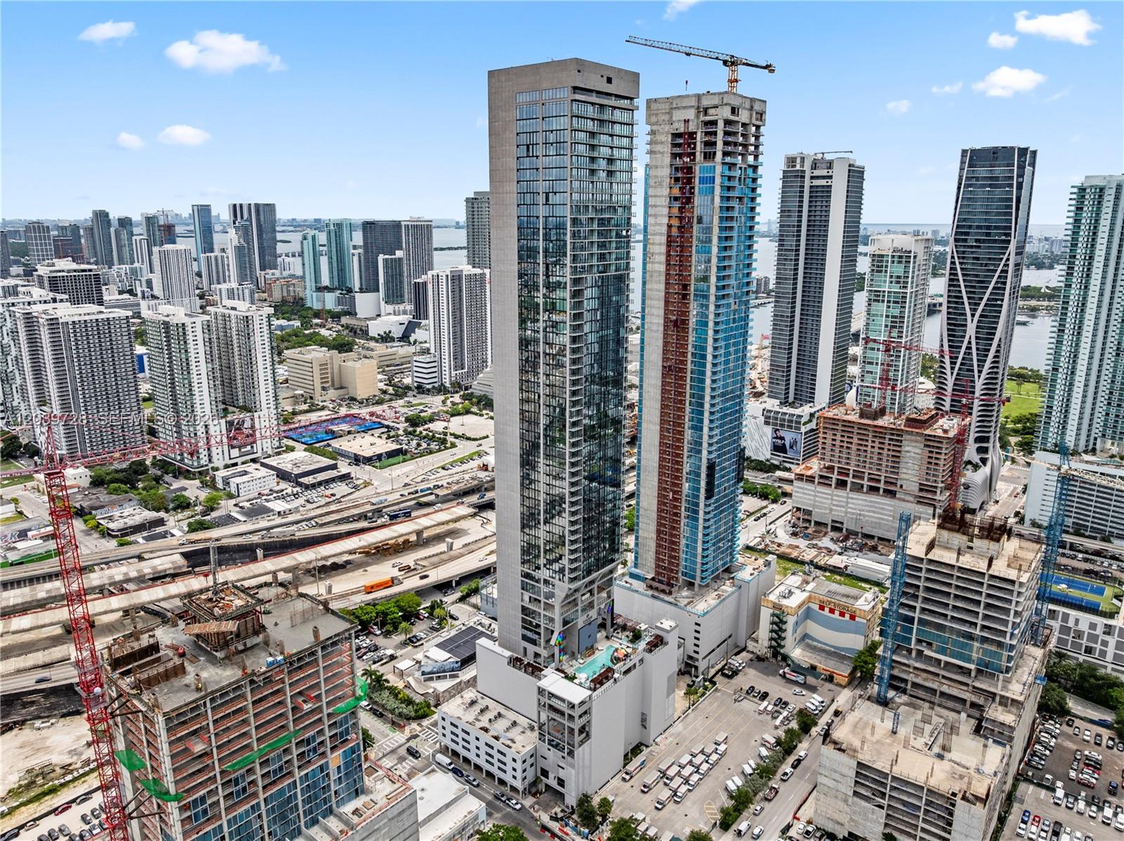 An aerial view shows several high-rise buildings under construction in a dense urban city — 20 NE 11th St # 2211, Miami FL 33132, MIAMI, FL
