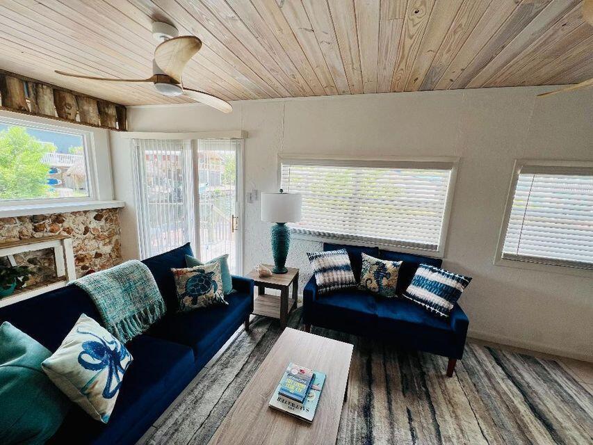 A living room features blue sofas, a wood-paneled ceiling, and a stone accent wall — 1540 Lantana Lane, FL 33043, FL