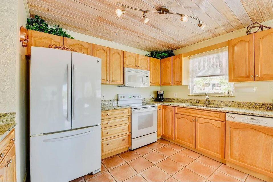 A kitchen with light wood cabinets, granite countertops, white appliances, and a wood-paneled ceiling — 1540 Lantana Lane, FL 33043, FL
