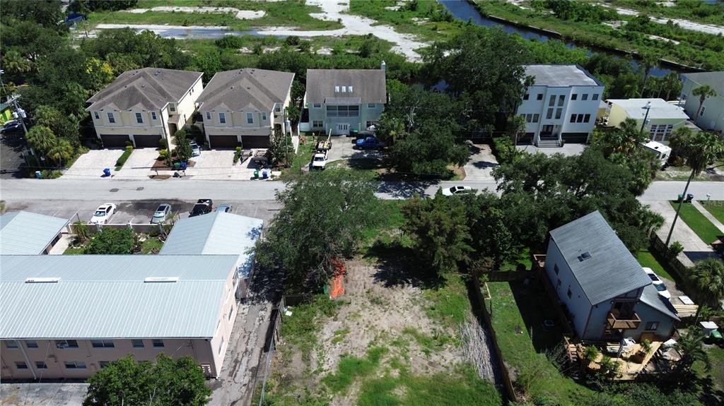 An aerial view shows a vacant lot situated between residential buildings and a paved street — 4813 W FLAMINGO ROAD, TAMPA, FL