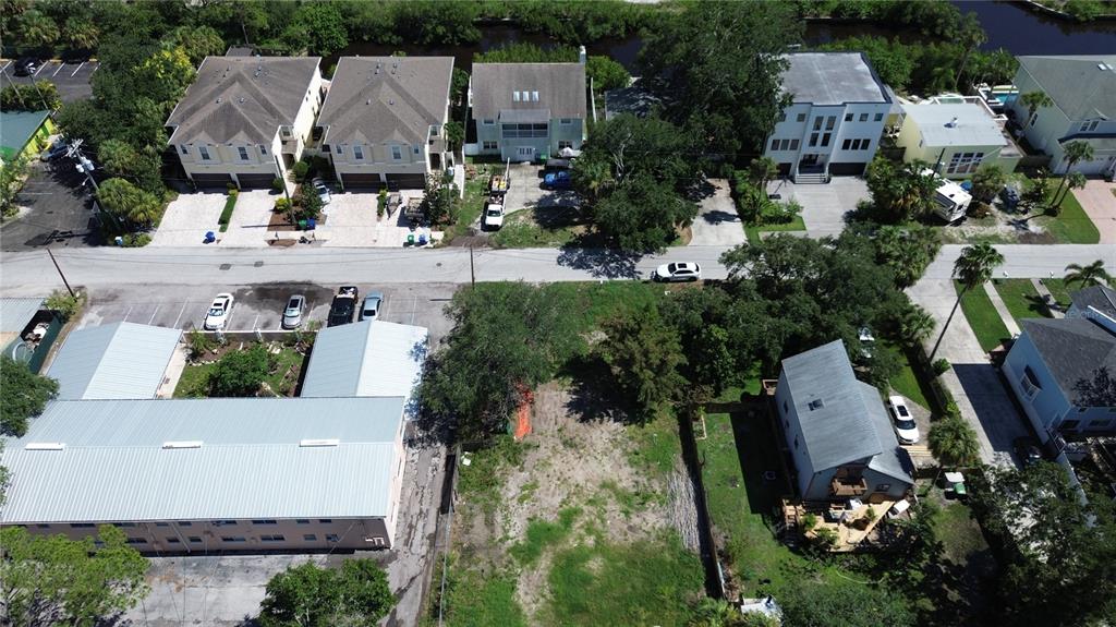 An aerial view shows a vacant lot situated between a multi-unit building and a house — 4813 W FLAMINGO ROAD, TAMPA, FL