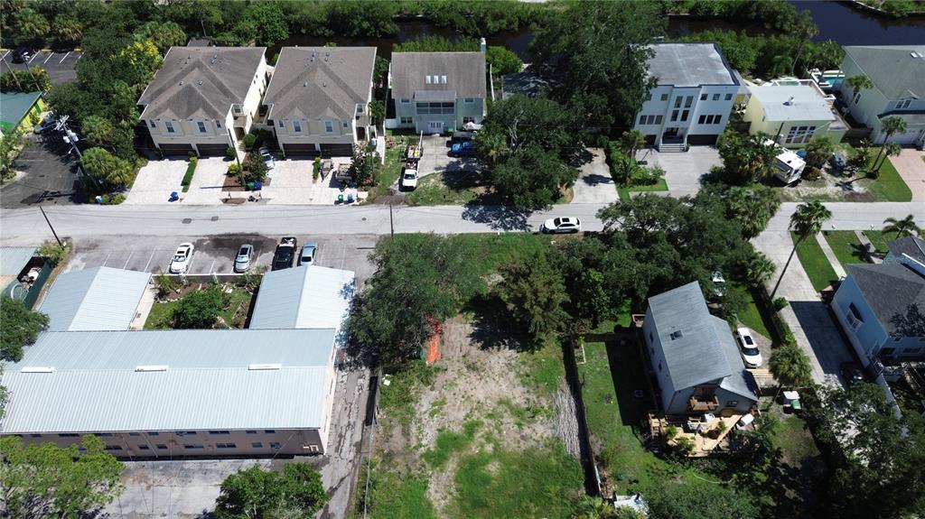 An aerial view shows a vacant lot situated between a multi-unit building and a house — 4813 W FLAMINGO ROAD, TAMPA, FL