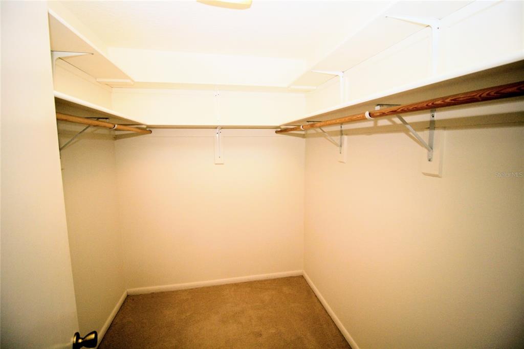 A bathroom features patterned wallpaper, a white vanity with a sink, and a toilet — 1033 GLENHAM DRIVE NE, PALM BAY, FL