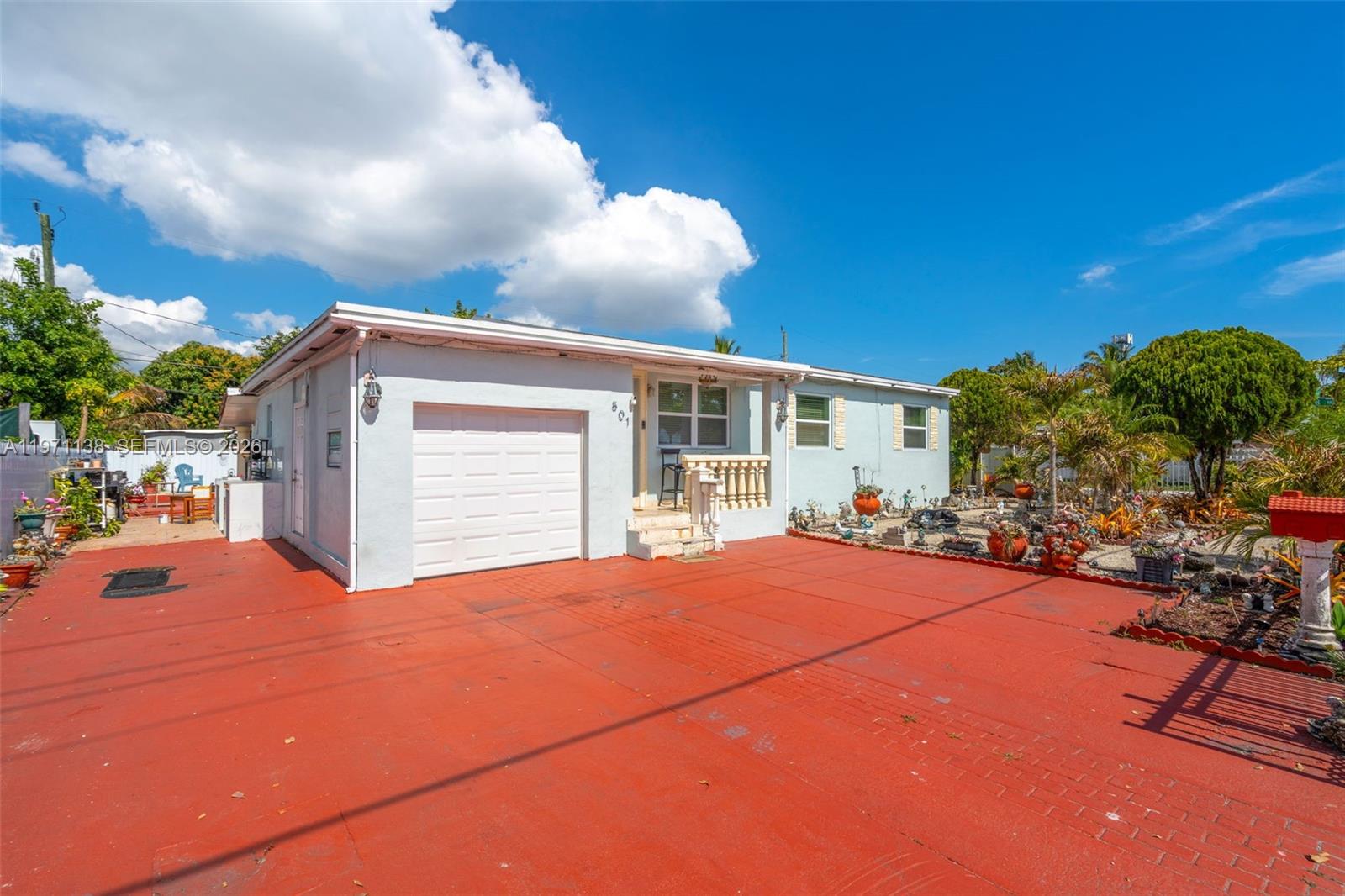 A single-story house with a white garage door and a red painted driveway — 801 OPA LOCKA BLVD, Miami FL 33168, MIAMI, FL