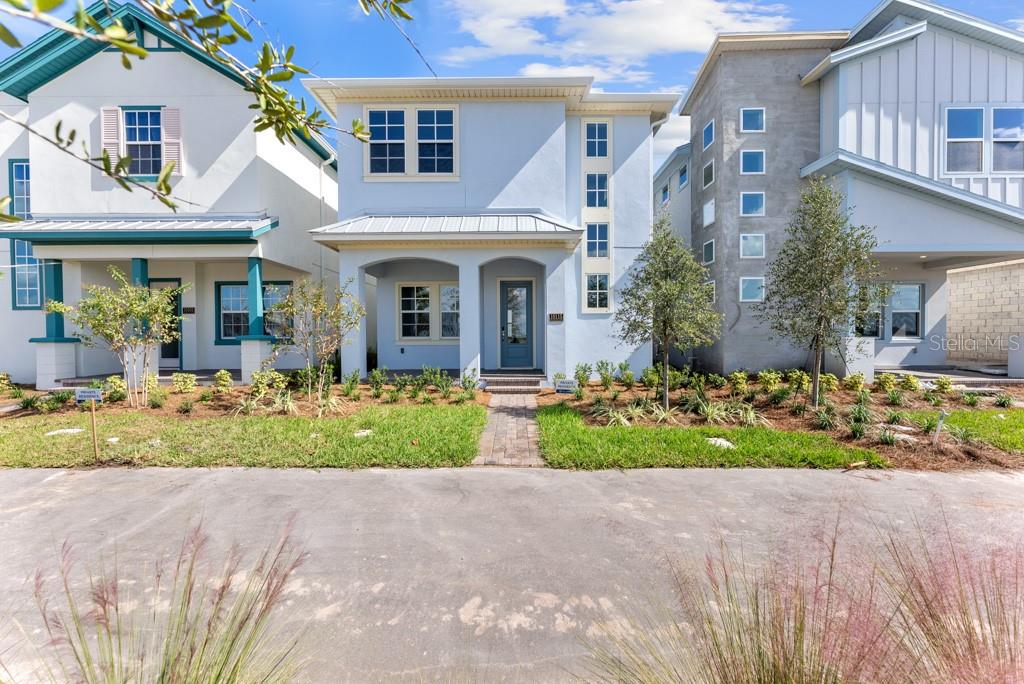 A light blue two-story house with a front porch and a brick walkway — 10115 PEARSON AVENUE, ORLANDO, FL