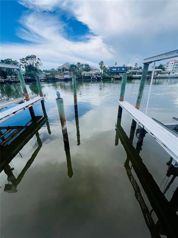 A view of a canal from a boat dock with wooden pilings and metal lifts — 300 VENETIAN DRIVE UNIT 3, CLEARWATER, FL