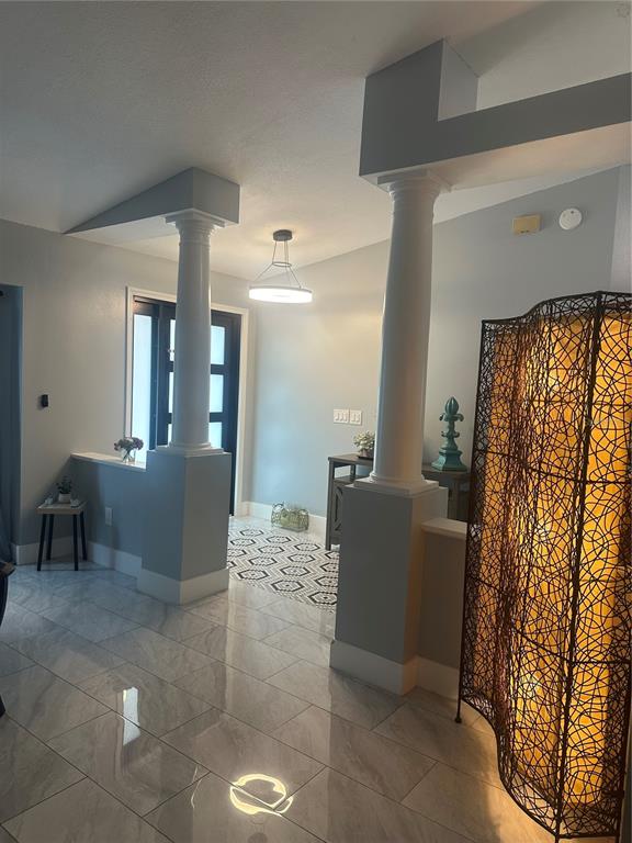 A foyer features two white columns, light gray walls, and polished tile flooring — 10924 MILL POND WAY, ORLANDO, FL