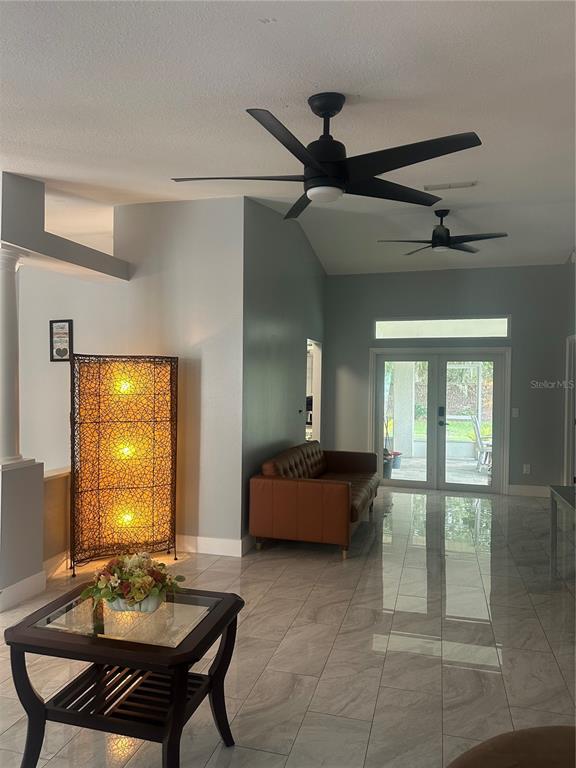A living room features light gray walls, tile flooring, two ceiling fans, and a leather sofa — 10924 MILL POND WAY, ORLANDO, FL