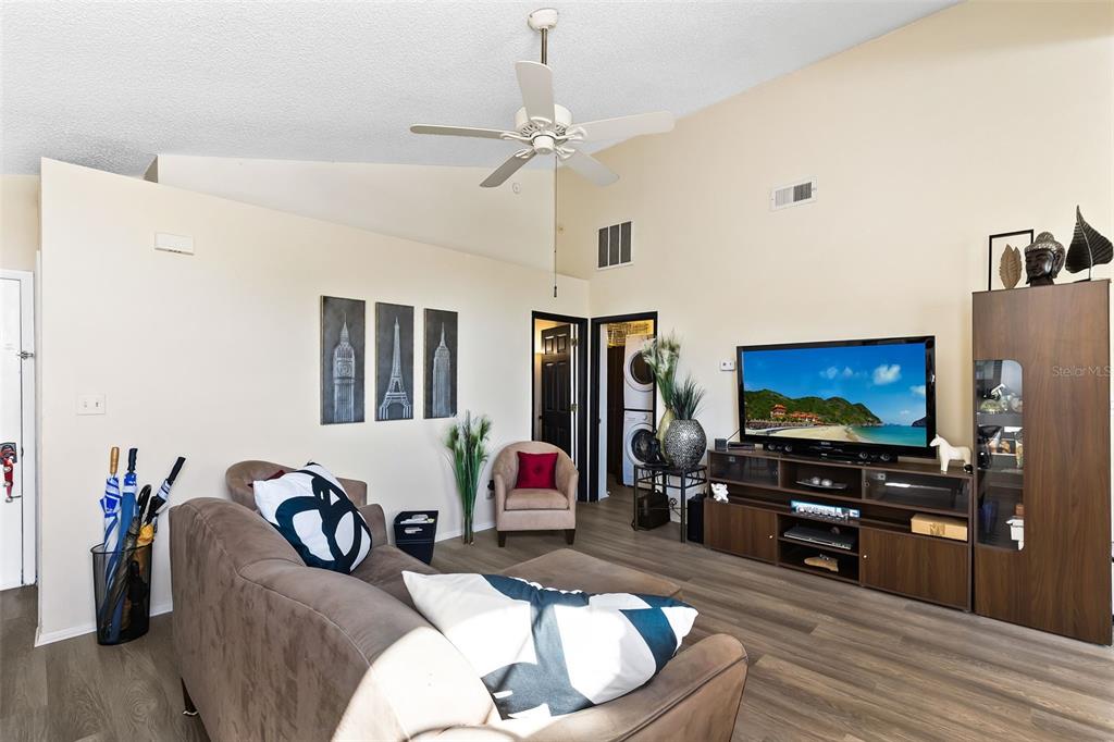 A living room features a brown sofa, a television on a media console, and a ceiling fan — 9808 SURREY RIDGE ROAD, ORLANDO, FL