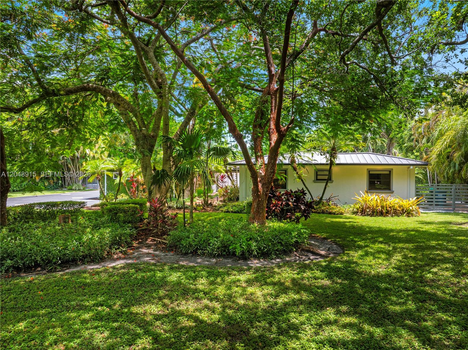 A white house with a metal roof is surrounded by lush trees and landscaping — 8735 SW 122nd St, Miami FL 33176, MIAMI, FL