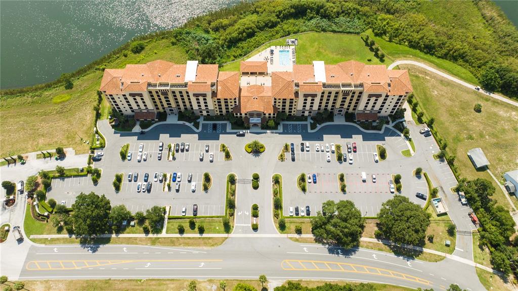 An aerial view shows a large multi-story building with a tiled roof and parking lot — 16300 COUNTY ROAD 455 UNIT 606, MONTVERDE, FL