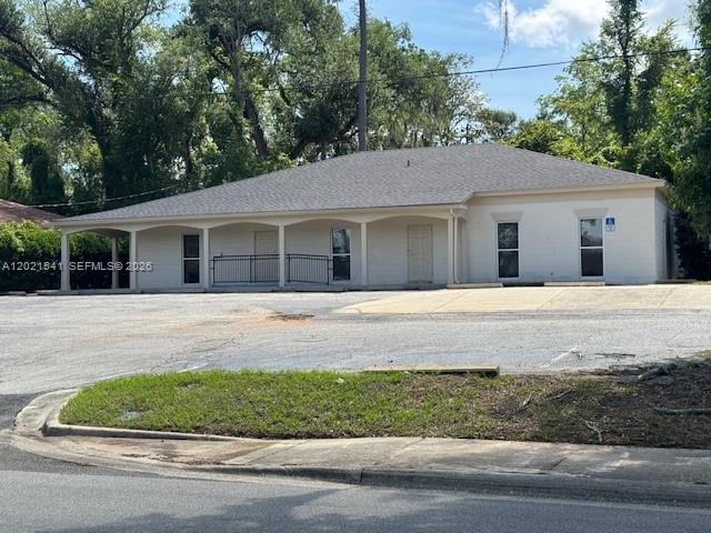 A single-story commercial building with a covered porch and parking lot sits under trees — 1707 S Gadsden, Tallahassee FL 32301, TALLAHASSEE, FL