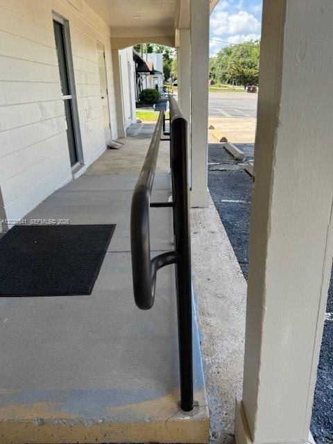 A metal handrail runs along a concrete walkway outside a building entrance — 1707 S Gadsden, Tallahassee FL 32301, TALLAHASSEE, FL