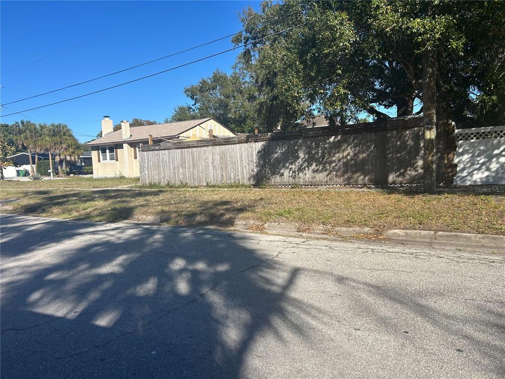 A wooden privacy fence borders a grassy yard next to a single-story house — 3324 W MARLIN AVENUE, TAMPA, FL