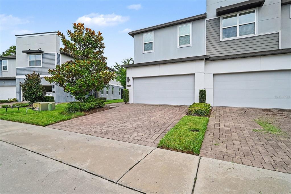 A modern two-story townhouse features a two-car garage and a paved driveway — 1427 BROAD WING LANE, WINTER PARK, FL