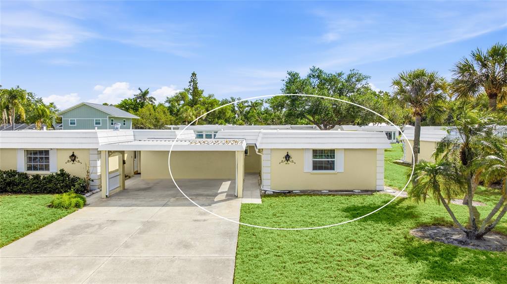 A single-story yellow house features a flat roof, a carport, and a grassy front yard — 5915 TIDEWOOD AVENUE UNIT 4, SARASOTA, FL