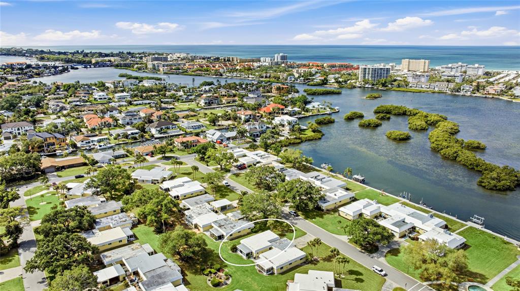 An aerial view shows a residential neighborhood with a circled house near a coastal waterway — 5915 TIDEWOOD AVENUE UNIT 4, SARASOTA, FL