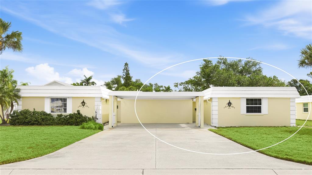 A yellow duplex features a shared carport between two separate residential units — 5915 TIDEWOOD AVENUE UNIT 4, SARASOTA, FL