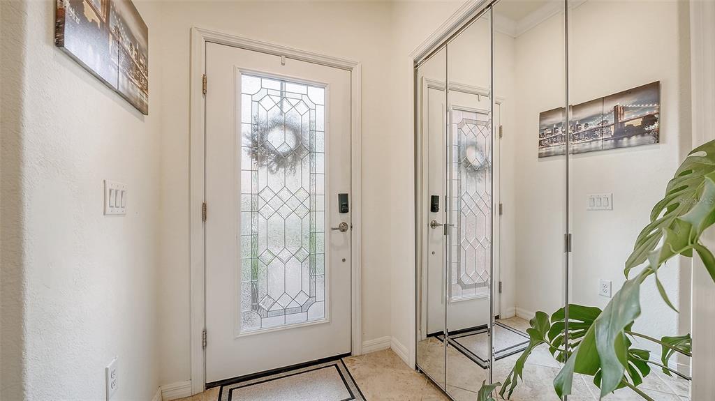An entryway features a white front door with a glass insert and mirrored closet doors — 20310 LAGENTE CIRCLE, VENICE, FL