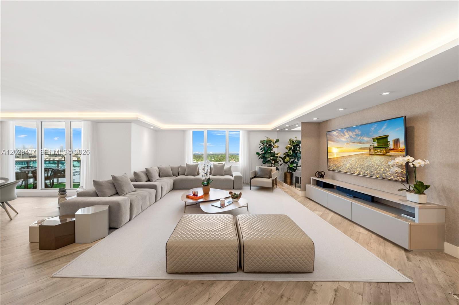 A spacious living room features a large sectional sofa, a television, and floor-to-ceiling windows — 2301 Collins Ave # 1432, Miami Beach FL 33139, MIAMI BEACH, FL