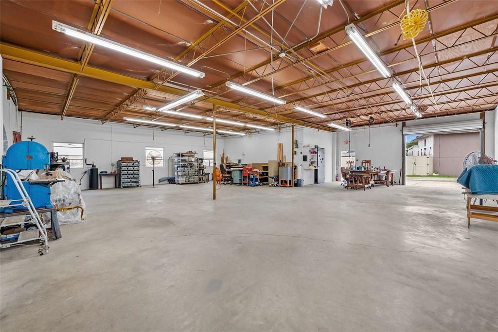 A large, open industrial workshop with a concrete floor, exposed ceiling, and fluorescent lighting — 1444 19TH STREET N, ST PETERSBURG, FL