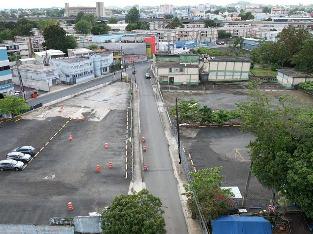 An elevated view of a narrow street separating two large, paved parking lots — 19 CALLE ONGAY, BAYAMON, PR