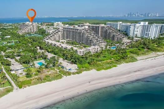 An aerial view shows a large beachfront apartment complex surrounded by trees and sandy beaches — 151 Crandon Blvd # 444, Key Biscayne FL 33149, KEY BISCAYNE, FL