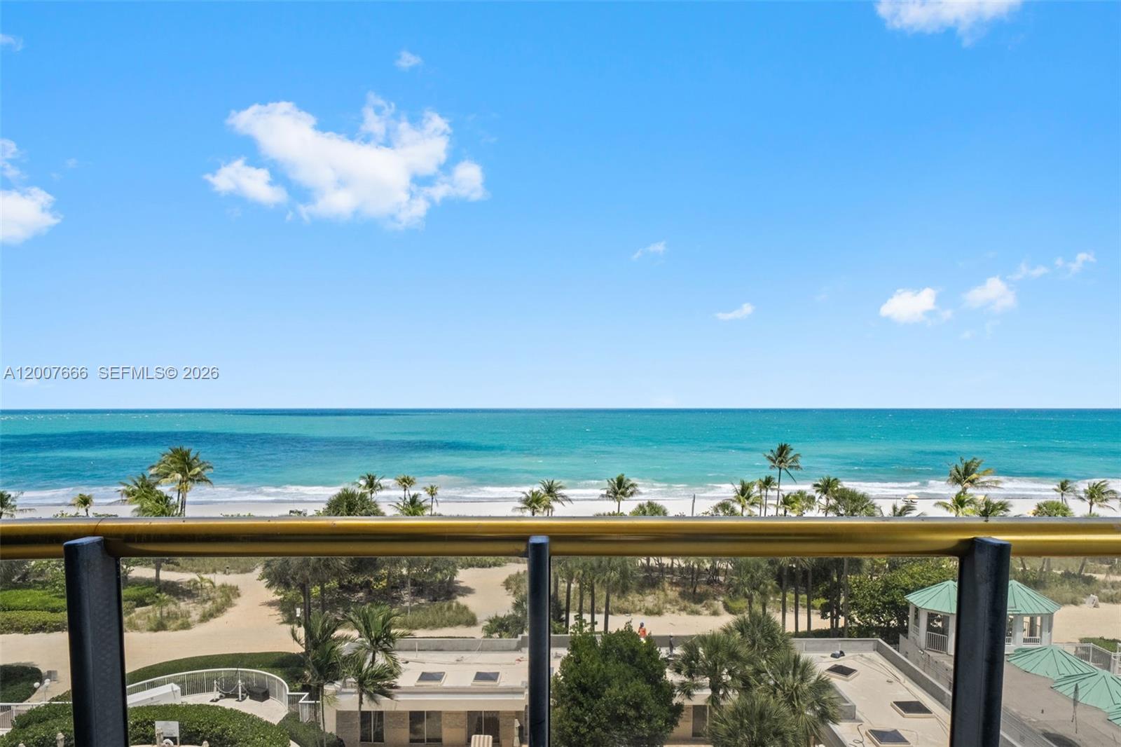 A balcony overlooks a sandy beach, palm trees, and the ocean under a blue sky — 9999 Collins Ave # 6G, Bal Harbour FL 33154, BAL HARBOUR, FL