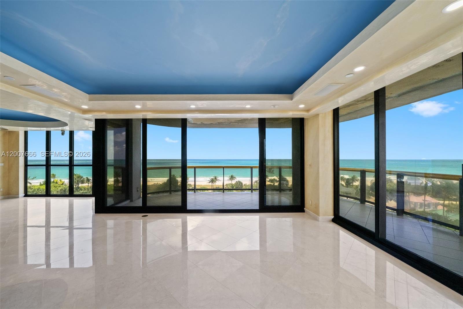 An empty room with white tile floors, a blue ceiling, and large sliding glass doors — 9999 Collins Ave # 6G, Bal Harbour FL 33154, BAL HARBOUR, FL