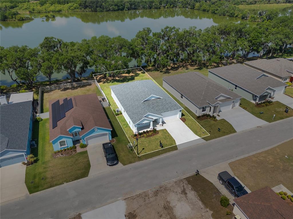 A light green single-story house with a two-car garage and a covered front porch — 4545 FAIRWAY OAKS DRIVE, MULBERRY, FL