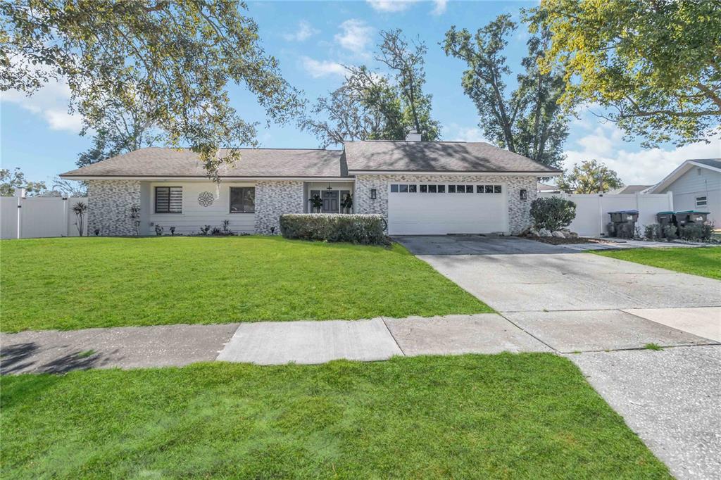 A single-story house with a white brick facade, a two-car garage, and a green lawn — 3912 CHERRY APPLE CIRCLE, ORLANDO, FL
