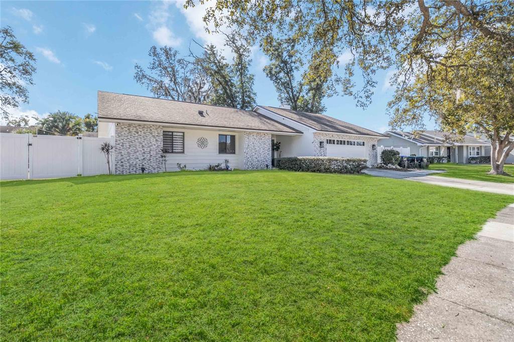 A single-story house with a white fence, stone accents, and a large front lawn — 3912 CHERRY APPLE CIRCLE, ORLANDO, FL