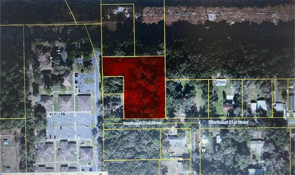 This is an aerial map showing a red-highlighted parcel of land near a street — 521 NE 31ST STREET, OCALA, FL