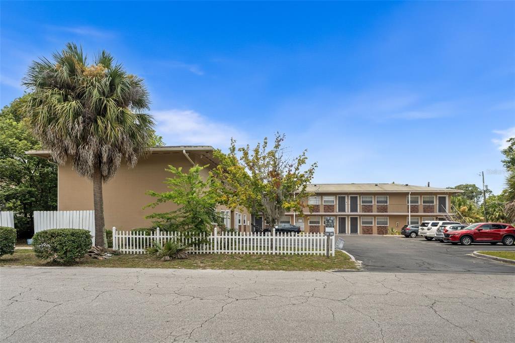 A two-story apartment building with a parking lot and a white picket fence — 501 NW 15TH AVENUE UNIT 11, GAINESVILLE, FL