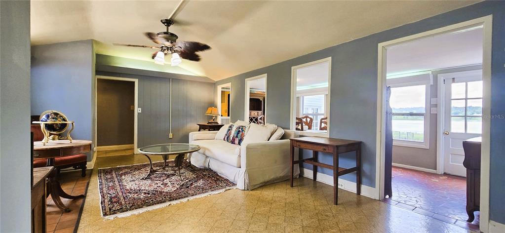 A living room features blue walls, a white sofa, a ceiling fan, and tiled flooring — 240 MASTERPIECE ROAD, LAKE WALES, FL