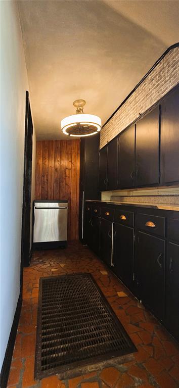 A narrow kitchen features black cabinets, a stainless steel dishwasher, and a tiled floor — 240 MASTERPIECE ROAD, LAKE WALES, FL