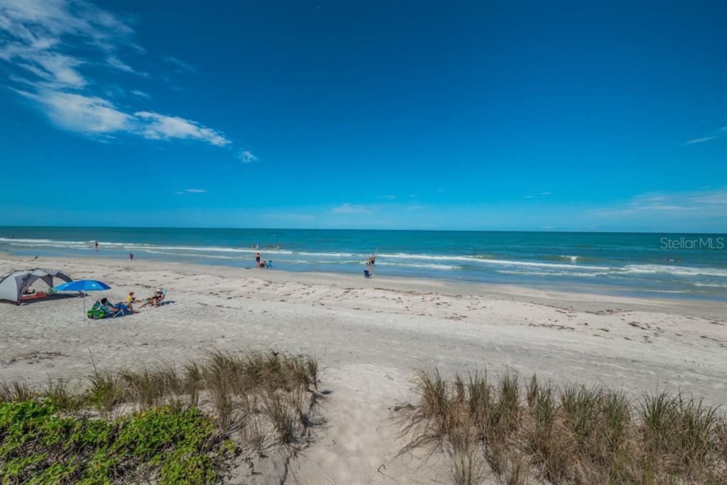 A sandy beach with people, umbrellas, and chairs under a clear blue sky — 372 12TH AVENUE, INDIAN ROCKS BEACH, FL