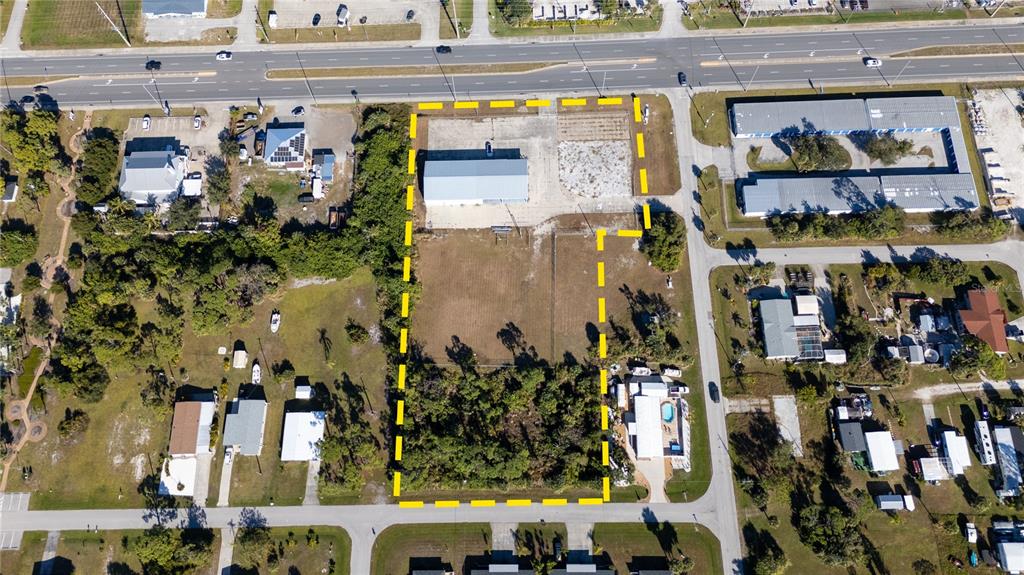 An aerial view shows a rectangular lot with a warehouse and vegetation outlined in yellow — 3060 PLACIDA ROAD, ENGLEWOOD, FL