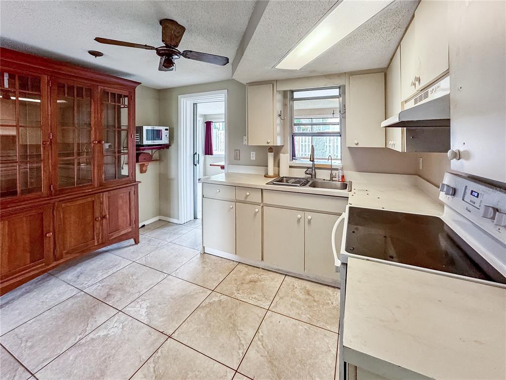 A kitchen with light-colored cabinets, tile flooring, a wooden hutch, and a ceiling fan — 934 FUNDY ROAD, VENICE, FL