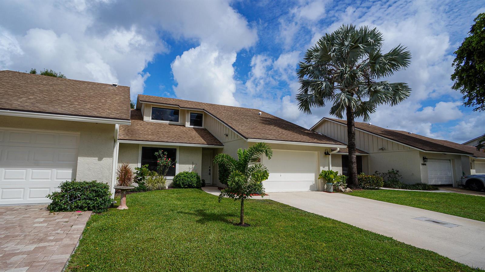 A beige two-story house with a brown shingled roof, a palm tree, and a driveway — 11894 Donlin Drive, Wellington FL 33414, WELLINGTON, FL