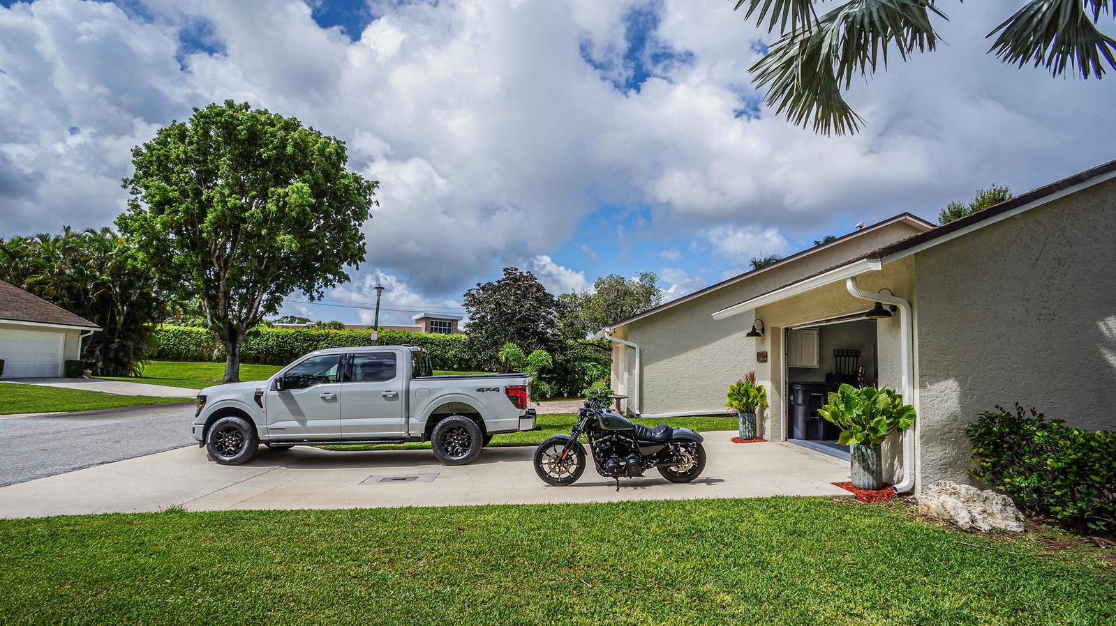 A light-colored pickup truck and a motorcycle are parked on a concrete driveway — 11894 Donlin Drive, Wellington FL 33414, WELLINGTON, FL