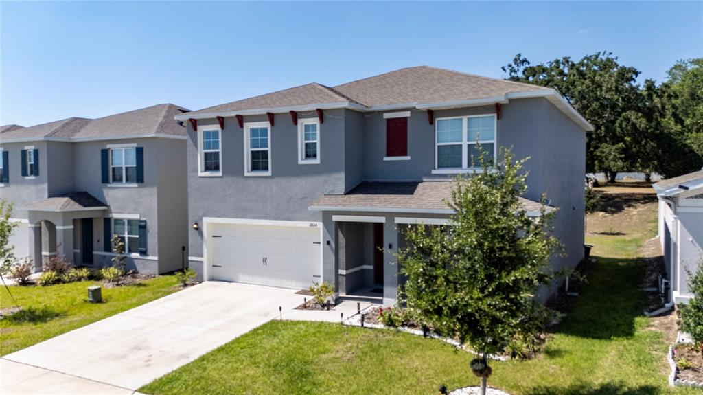 A two-story gray house with a white garage door and a front yard — 2824 BIG SUR ROAD, DAVENPORT, FL