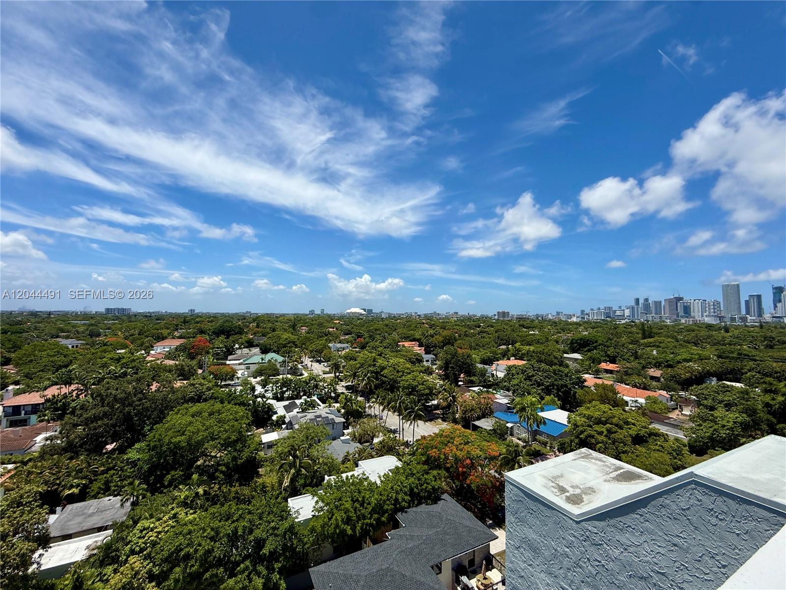 An elevated view shows a residential neighborhood with lush trees and a distant city skyline — 2950 SW 3rd Ave # 3C, Miami FL 33129, MIAMI, FL