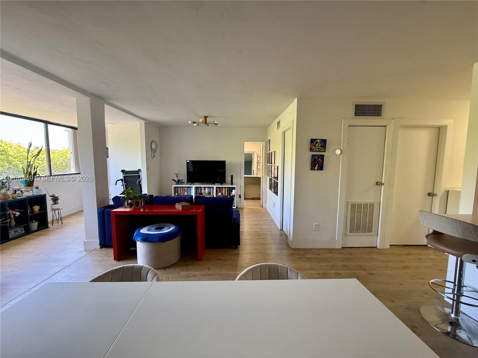 A living room features a blue sofa, a red console table, and light wood flooring — 2950 SW 3rd Ave # 3C, Miami FL 33129, MIAMI, FL