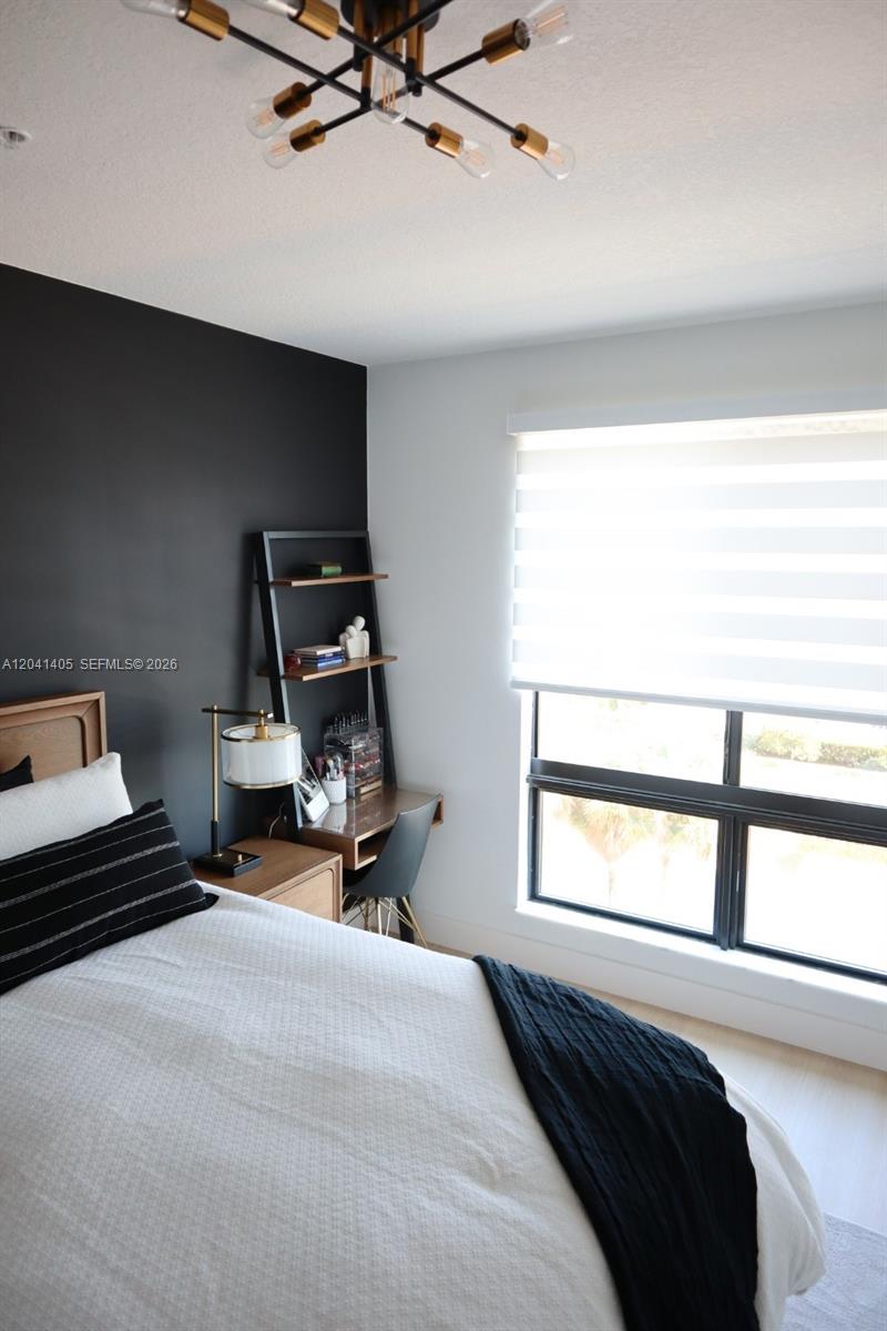 A bedroom features a black accent wall, a wooden bed frame, and a ladder desk — 8201 NW 41st St # 402, Doral FL 33166, DORAL, FL