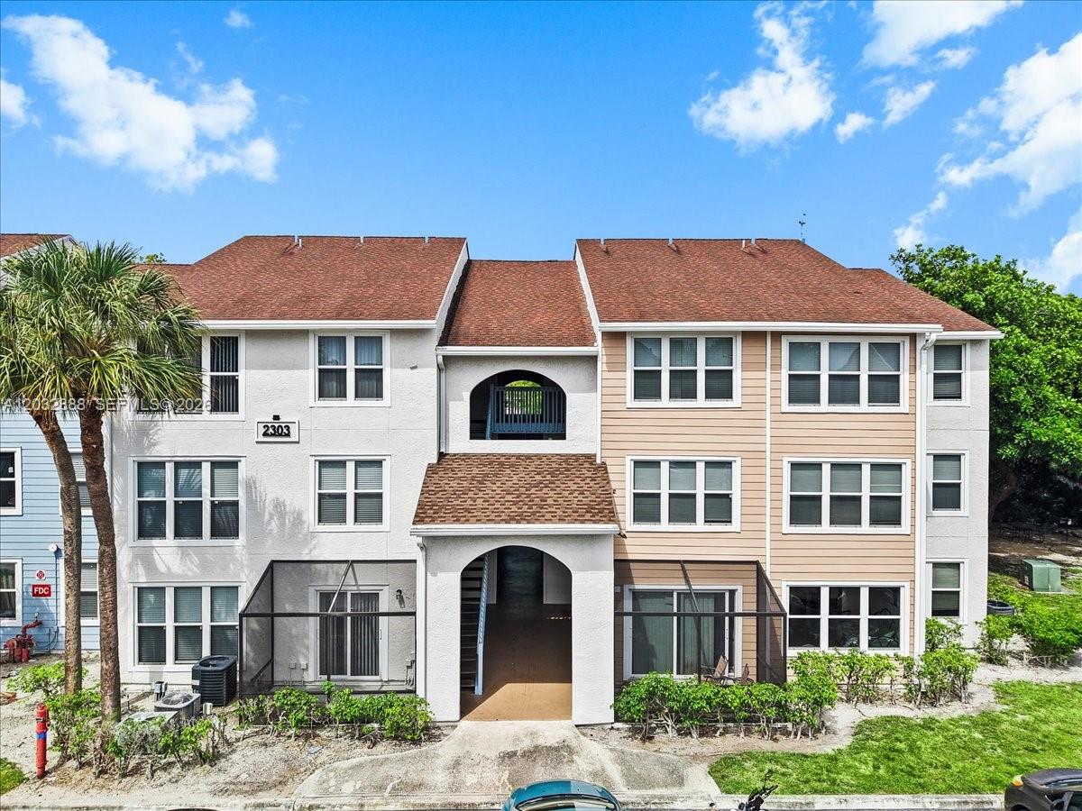 A three-story apartment building with a brown shingled roof and a central arched entryway — 2303 N Congress Ave # 27, Boynton Beach FL 33426, BOYNTON BEACH, FL